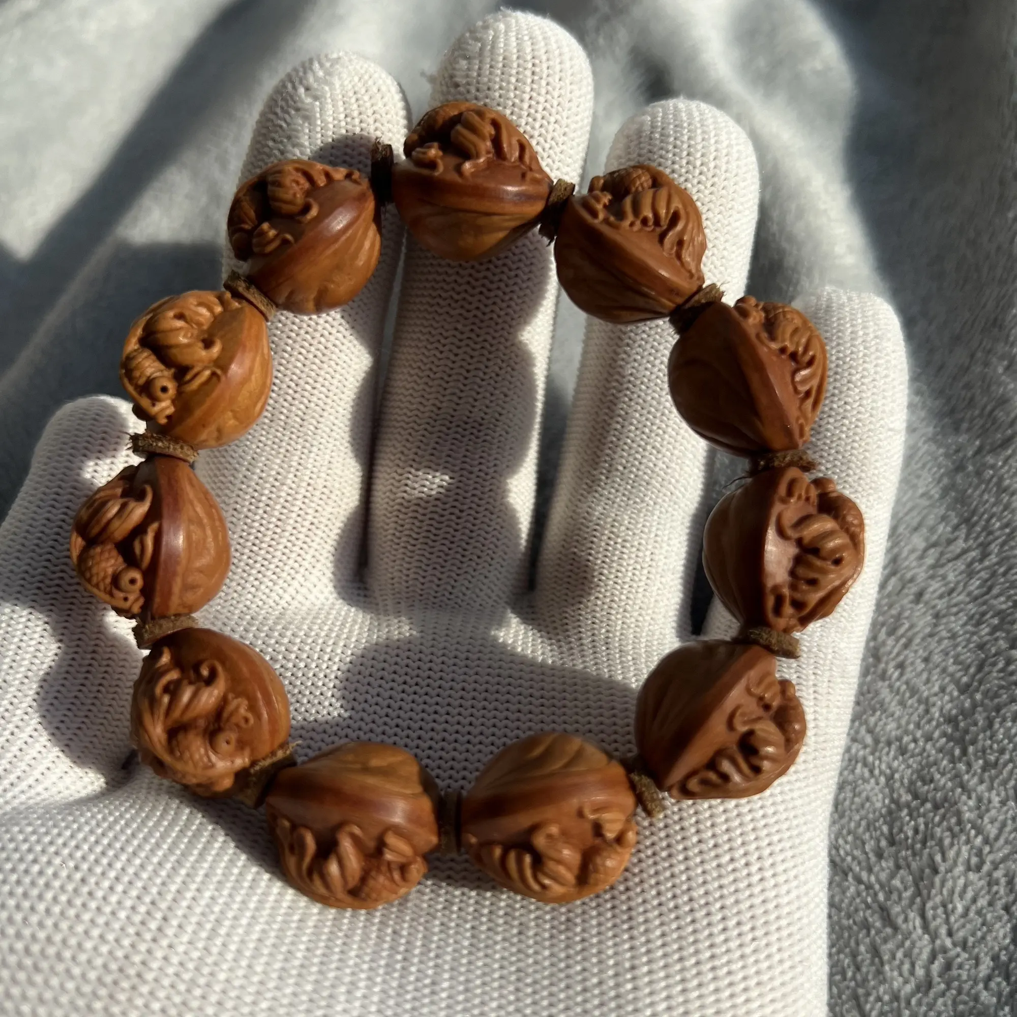 野生龙纹桃核手工雕刻蝶尾金鱼手串。